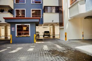 a blue building with a car parked in a parking lot at Lakeview 3Bedroom Condo with heated pool in Nakuru Town in Nakuru