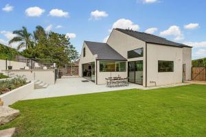 a white house with a patio and a yard at Modern Encinitas Retreat in Encinitas
