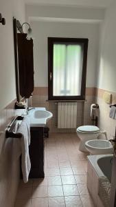 a bathroom with two sinks and a toilet and a window at MAREMONTI alloggio turistico in Formia +26 photos