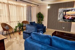 a living room with a blue couch and chairs at Lakeview 3Bedroom Condo with heated pool in Nakuru Town in Nakuru