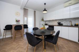 a kitchen with a table and chairs in a kitchen at Lux suite in Split- Jacuzzi&Gym&more in Solin
