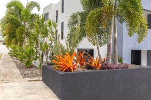 a planter with palm trees and plants in front of a building at Luxury Bliss in Runaway Bay
