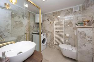 a bathroom with a sink and a washing machine at Lux suite in Split- Jacuzzi&Gym&more in Solin +34 photos
