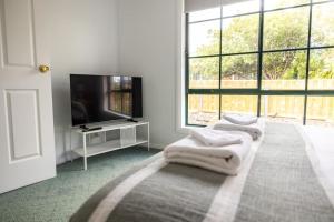 a white room with a tv and two white towels at Nautilus Nest - Port Sorell in Port Sorell