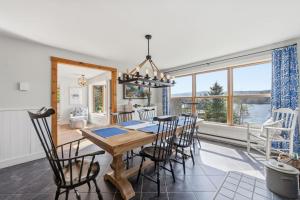 a dining room with a table and chairs and a large window at Oceanfront House Steps to Water in French Village
