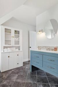 a bathroom with a blue vanity and a mirror at Oceanfront House Steps to Water in French Village +50 photos