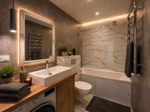 a bathroom with a sink and a toilet and a tub at Апартаменти VIP in Ternopil