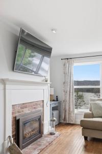 a living room with a fireplace and a window at Oceanfront House Steps to Water in French Village