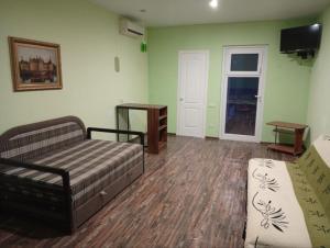 a living room with a couch and a tv at Villa Klavia in Zatoka