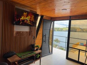 a room with a door and a view of the water at Lago de Tota GALAMPLAY lodge in Tota