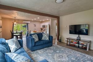 a living room with a blue couch and a tv at Lil Blue Dog Haven in Sagle