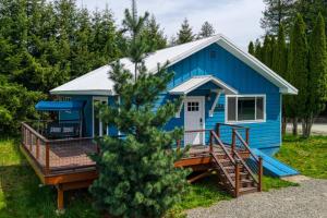 a blue tiny house with a porch at Lil Blue Dog Haven in Sagle