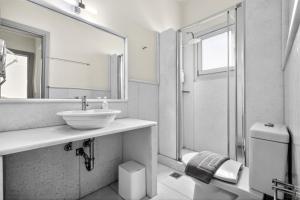 a bathroom with a sink and a mirror and a shower at Mimoza in Spetses