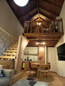 a living room with a staircase and a table and chairs at Anoi Kalymnos in Khoríon