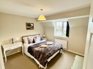 a bedroom with a bed and a window at Hideaway Cottage in Bourton on the Water