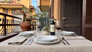 a table with plates and glasses and a bottle of wine at [10 minuti dall'aeroporto] Linate Studio Flat in Peschiera Borromeo