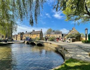 a bridge over a river in a small town at Hideaway Cottage in Bourton on the Water