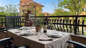 a table with plates and wine glasses on a balcony at [10 minuti dall'aeroporto] Linate Studio Flat in Peschiera Borromeo