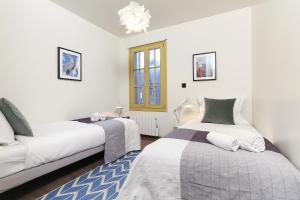 シャモニー・モンブランにあるCHALET SUISSE - Alpes Travel - Central Chamonix - sleeps 4のベッドルーム1室(ベッド2台、シャンデリア付)