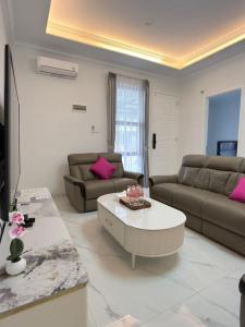 a living room with two couches and a coffee table at Noble Cove Batam in Pulau Sembakau Kecil