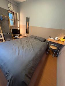 ein Schlafzimmer mit einem Bett, einem Schreibtisch und einer Uhr in der Unterkunft beach house in Amami + 4 Fotos