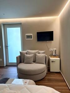 a living room with a couch and a flat screen tv at Trulli Dafani in Ostuni