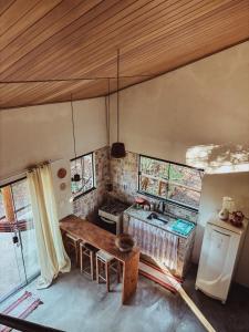 a kitchen with a wooden table in a room at Girassóis do Vale - Chalés no Vale do Capão in Caeté-Açu