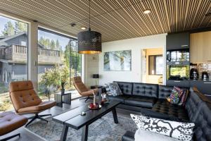 a living room with a black leather couch and chairs at Stay North - Villa Mono in Pälkäne