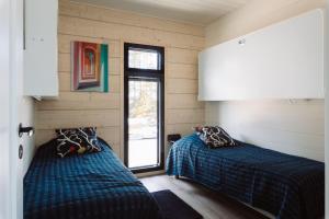 two beds in a room with a window at Stay North - Villa Mono in Pälkäne