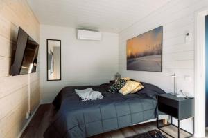 a bedroom with a blue bed and a television at Stay North - Villa Mono in Pälkäne
