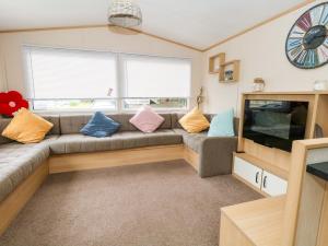 a living room with a couch and a tv at Foxglove 4 in Ringwood