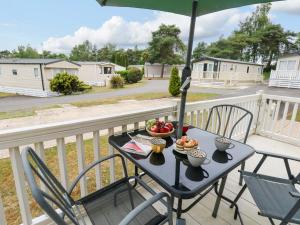 a table with food on a balcony with an umbrella at Foxglove 4 in Ringwood