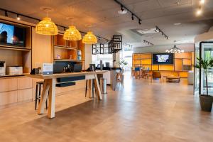a large room with tables and chairs in a building at Ibis Porto Alegre Assis Brasil - Estacionamento Gratuito para hospedes in Porto Alegre