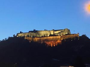 a castle on top of a hill at night at B&B Giù di sotto in Gavi