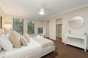 a white bedroom with a large bed and a mirror at The Grand Aveley House in The Vines