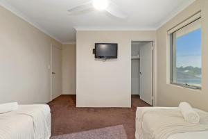 a bedroom with two beds and a tv on the wall at The Grand Aveley House in The Vines