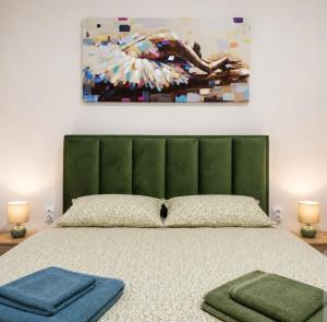 a bedroom with a bed with a green headboard and a painting at Zaga Bloom Apartment in Banja Koviljača
