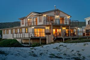 a large house on the beach at night at Dune Rose Yzerfontein Villa in Yzerfontein