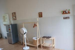 a kitchen with a refrigerator and a table with a fan at Tran Phu Riverside House in Can Tho