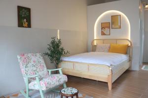 a small bedroom with a bed and a chair at Tran Phu Riverside House in Can Tho