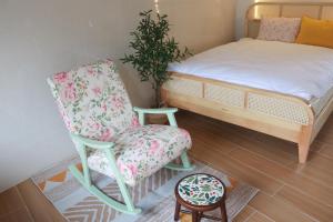 a bedroom with a bed and a chair and a table at Tran Phu Riverside House in Can Tho