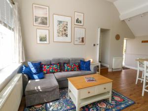 a living room with a couch and a table at Sea Pink Cottage in Swanage