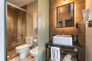 a bathroom with a sink and a toilet and a mirror at Up Barrio Norte in Buenos Aires