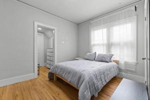 a white bedroom with a bed and a window at 2 BR - Fully Equipped Dearborn Home in Dearborn