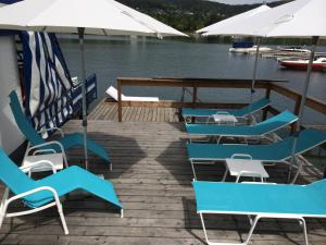 a group of blue chairs and umbrellas on a dock at Hotel Garni Wurzer in Velden am Wörthersee