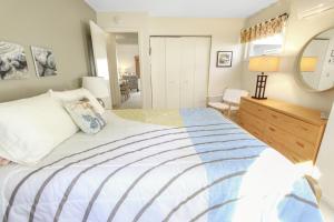 a bedroom with a bed and a dresser and a mirror at Coastal Cozy in Brewster