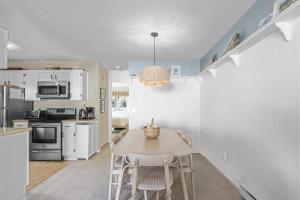a kitchen and dining room with a table and chairs at Coastal Cozy in Brewster