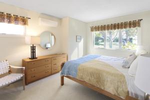 a bedroom with a bed and a dresser and a window at Coastal Cozy in Brewster