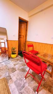 a red chair and a table in a room at Jamming Tree in Manāli