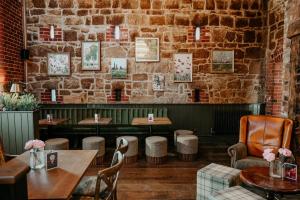 a restaurant with tables and chairs and a brick wall at The Bubble at Stenson in Stanton